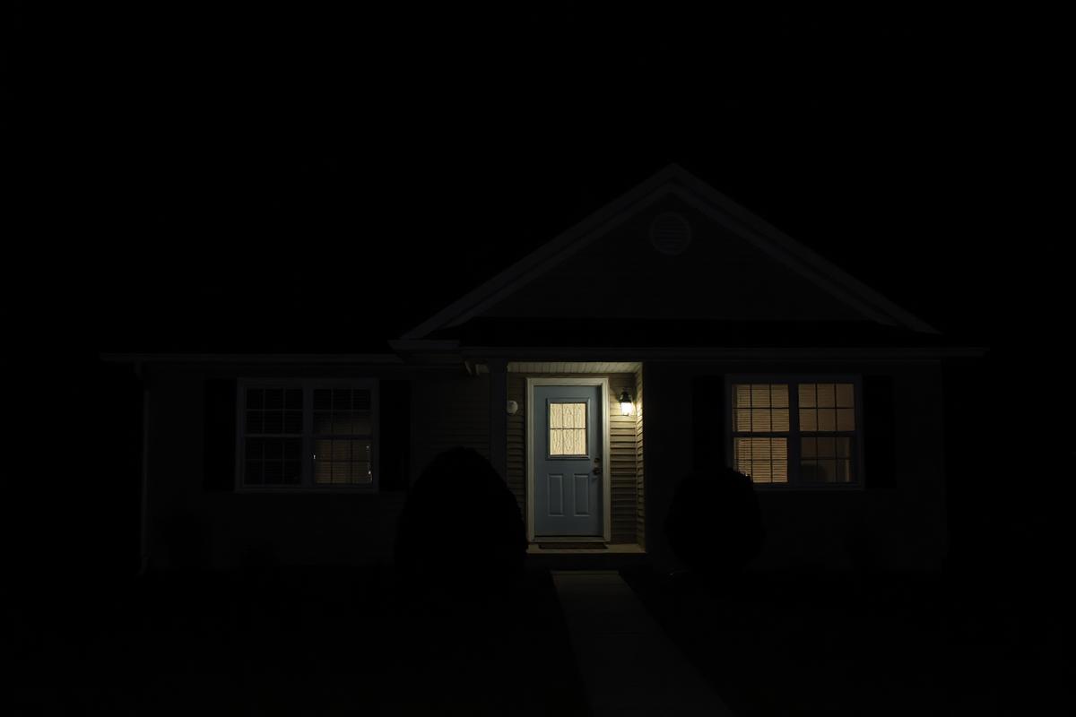 Dark unlit suburban home at night with poor curb appeal